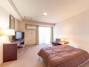 a hotel room with a bed and a desk and a television at Tabist Hotel Paramount in Urasa Minami-Uonuma in Minami Uonuma