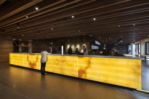 a man standing at a yellow counter in a restaurant at Jasper Boutique Hotel in Melbourne