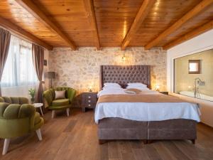 a bedroom with a large bed and two chairs at Harmonia Bungalows & Pool in Sveti Stefan