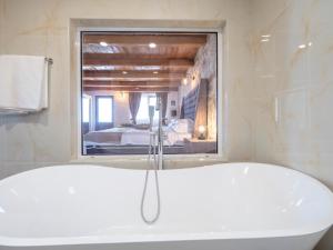 a bath tub in a bathroom with a bedroom at Harmonia Bungalows & Pool in Sveti Stefan