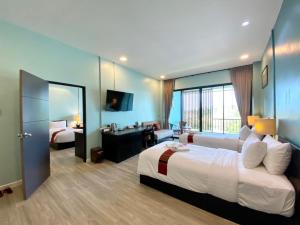 Habitación de hotel con cama grande y sala de estar. en Maikaew Damnoen Resort en Damnoen Saduak
