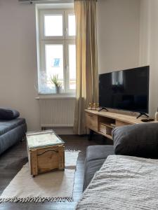 a living room with a couch and a table and a television at Ferienwohnung Kamrath Altstadt von Neuruppin in Neuruppin