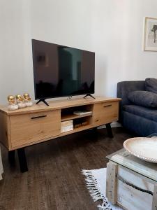 a living room with a television on a wooden entertainment center at Ferienwohnung Kamrath Altstadt von Neuruppin in Neuruppin