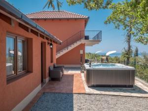 a house with a hot tub and a balcony at Harmonia Bungalows & Pool in Sveti Stefan
