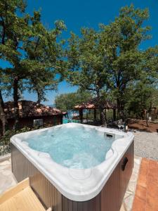 a hot tub in a backyard with trees in the background at Harmonia Bungalows & Pool in Sveti Stefan