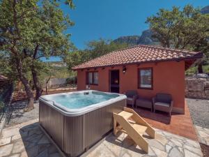 a hot tub in front of a small house at Harmonia Bungalows & Pool in Sveti Stefan