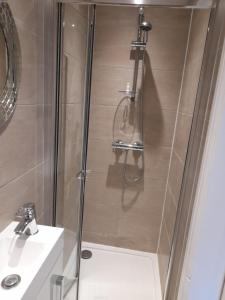 a shower with a glass door next to a sink at Lovely Home with full en-suite double bed rooms in Reading