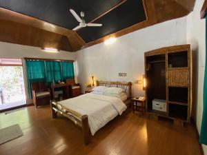 um quarto com uma cama e uma ventoinha de tecto em Wild Orchid em Ilha Havelock