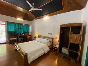 1 dormitorio con 1 cama y ventilador de techo en Wild Orchid en Havelock Island