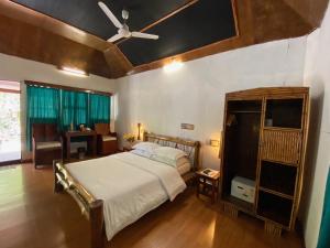 a bedroom with a bed and a ceiling fan at Wild Orchid in Havelock Island