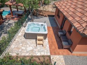 a hot tub in a yard next to a house at Harmonia Bungalows & Pool in Sveti Stefan