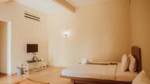 um quarto com uma cama e uma secretária com uma televisão em Blessing Hills Family Resort & Hotel em Mojokerto