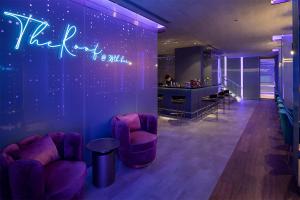 a room with purple chairs and a bar at Mode Sathorn Hotel - SHA Extra Plus in Bangkok