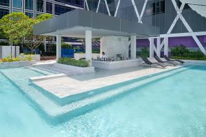 una piscina con 2 sillas frente a un edificio en Mode Sathorn Hotel - SHA Extra Plus, en Bangkok