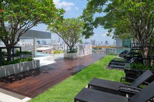a rooftop deck with benches and trees on a building at Mode Sathorn Hotel - SHA Extra Plus in Bangkok