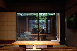 a room with a wooden table and a patio at Reikaku Yasaka in Kyoto