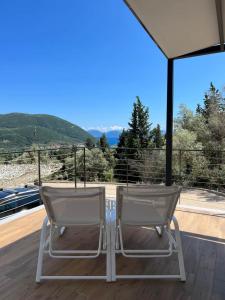 twee stoelen op een terras met uitzicht op een berg bij Vasiliki Houses in Vasiliki