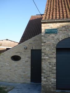 un bâtiment en briques avec une porte et un garage dans l'établissement B&B Hoeve 't Geleed, à Damme