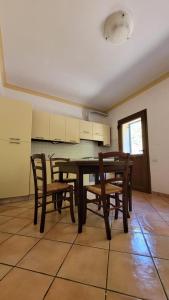 uma sala de jantar com uma mesa de madeira e cadeiras em Cortebella B&B Rimini em Vergiano