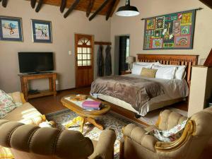 a bedroom with a bed and a living room at Gerty's in Pretoria