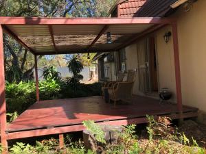 Gerty's في بريتوريا: سطح خشبي مع شمسية على منزل