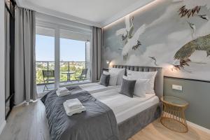 una camera da letto con un grande letto con una grande finestra di Downtown Apartments Gdynia Modern Tower a Gdynia