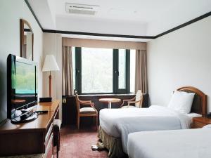 Habitación de hotel con 2 camas y TV de pantalla plana. en The K Hotel Gyeongju en Gyeongju