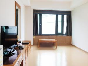a living room with a large window and a table at The K Hotel Gyeongju in Gyeongju