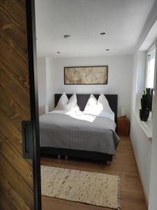 una camera da letto con un letto con cuscini bianchi di Ferienwohnung Tritscher a Saalfelden am Steinernen Meer