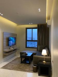 a living room with a couch and a tv at فخامة المشارف للشقق المخدومة in Abha