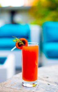 a red drink with a carrot on top of it at La Villa Residence Hotel in Kigali