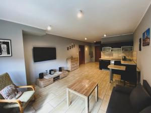 a living room with a table and a kitchen at Apartamenty Energo in Bytom