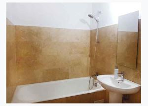 La salle de bains est pourvue d'un lavabo et d'une baignoire. dans l'établissement Piata Victoriei Sanador Studio Apartment, à Bucarest