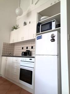 a white kitchen with a refrigerator and a microwave at Centrally located Apt 22 - Smugglers Inn in Victor Harbor