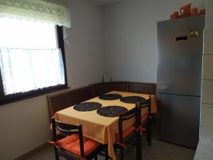 Il comprend une cuisine équipée d'une table, de chaises et d'un réfrigérateur. dans l'établissement Hiša Belin, à Podbela
