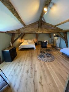 een slaapkamer met een bed en een houten vloer bij L Ecrin de Bricabeau Longère en pierres avec piscine privative in Saint-Méard-de-Gurçon +8 foto's