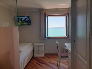 a small bedroom with a bed and a window at Hotel Strand-Cafe Meersburg in Meersburg