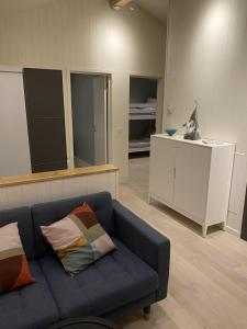 una sala de estar con un sofá azul y un gato sentado en un mostrador en Ekberg Annexet, en Järvsö