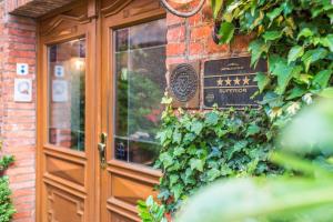 a wooden door with ivy on the side of a building at Romantik Hotel Reichshof in Norden