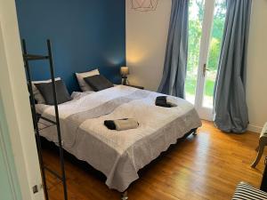 Un dormitorio con una cama en una habitación con ventana. en Villa Le grand Renard, en Saint-Antoine-Cumond 19 fotos más