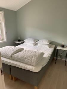 a bedroom with a large bed with white sheets and pillows at Ekberg Annexet in Järvsö