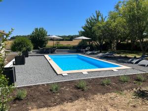 Una piscina en un patio con sillas alrededor. en Villa Le grand Renard, en Saint-Antoine-Cumond