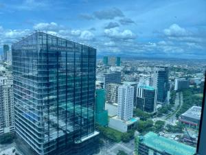 vista su una città con un edificio alto di Bright 2-bedroom condo with pool in BGC Uptown a Manila