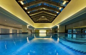 einem großen Pool in einem Gebäude mit einer Decke in der Unterkunft Kunshan Yu Yuan Garden Hotel in Kunshan