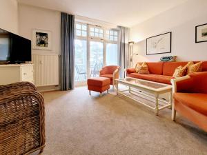 een woonkamer met een bank en een tafel bij Villa Strandidyll in Binz - WG 11 mit Meerblick und zwei Balkonen in Binz