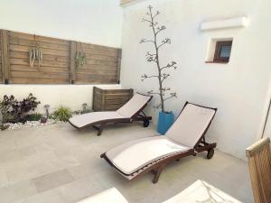 dwa krzesła siedzące na patio z drzewem w obiekcie La Gata Azul Rodalquilar w mieście Rodalquilar