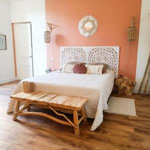 a bedroom with a large bed and a bench at Chambres d'hotes - Le Magnolia in Carcassonne