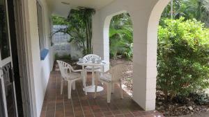 a patio with a table and chairs on a porch at 11 Murray in Nelly Bay