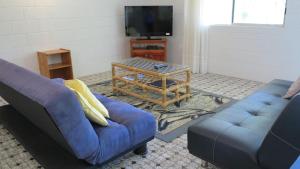 a living room with two blue couches and a table at 11 Murray in Nelly Bay