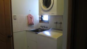 a small kitchen with a sink and a microwave at Arcadia Gardens in Arcadia +5 photos